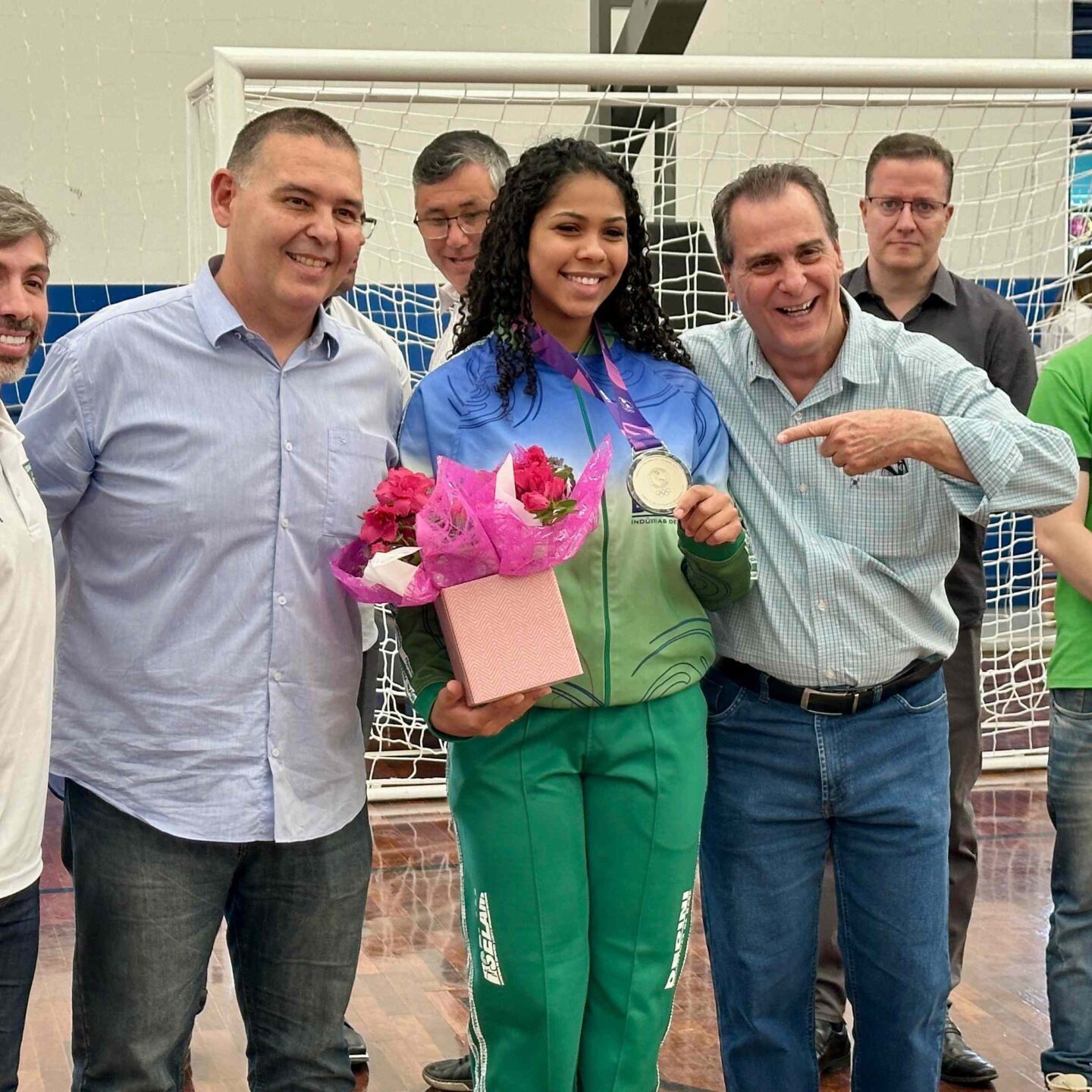01-09-Ginásio (Jaraguá)-1 Com a medalha no peito, Bárbara Borges, ao lado do treinador Diego, secretário Roger Carneiro e do prefeito Helinho Zanatta, também foi homenageada - foto: Divulgação